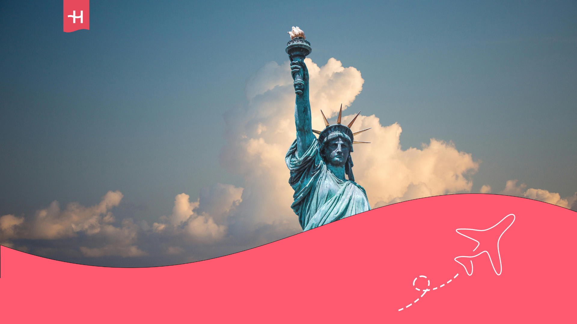 The Statue of Liberty standing against a blue sky with cotton candy clouds in the background.