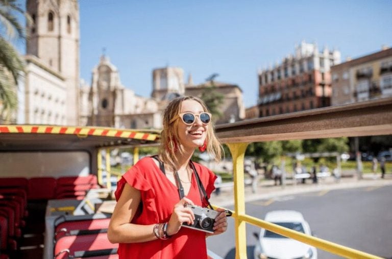A smiling woman in Spain holding a camera