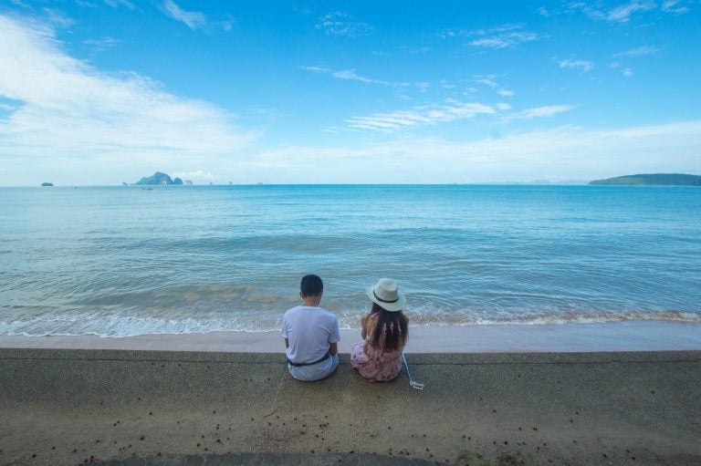 couple sitting in a beach in thailand