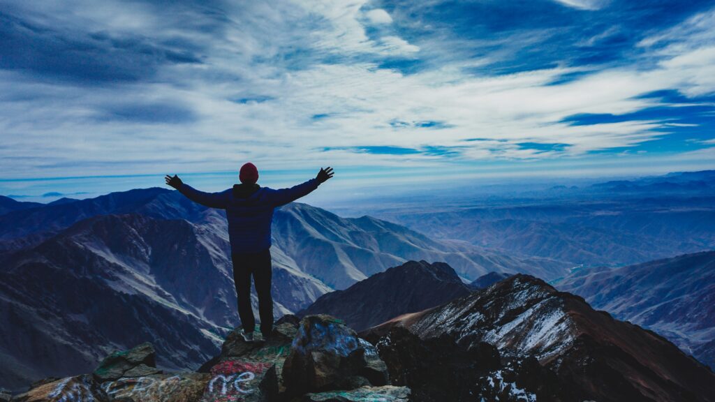 An image of a person at the edge of a mountain