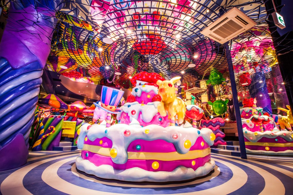 Colorful photo of Kawaii Monster Cafe, including a giant pink cake, spiral floor, and disco ceiling.