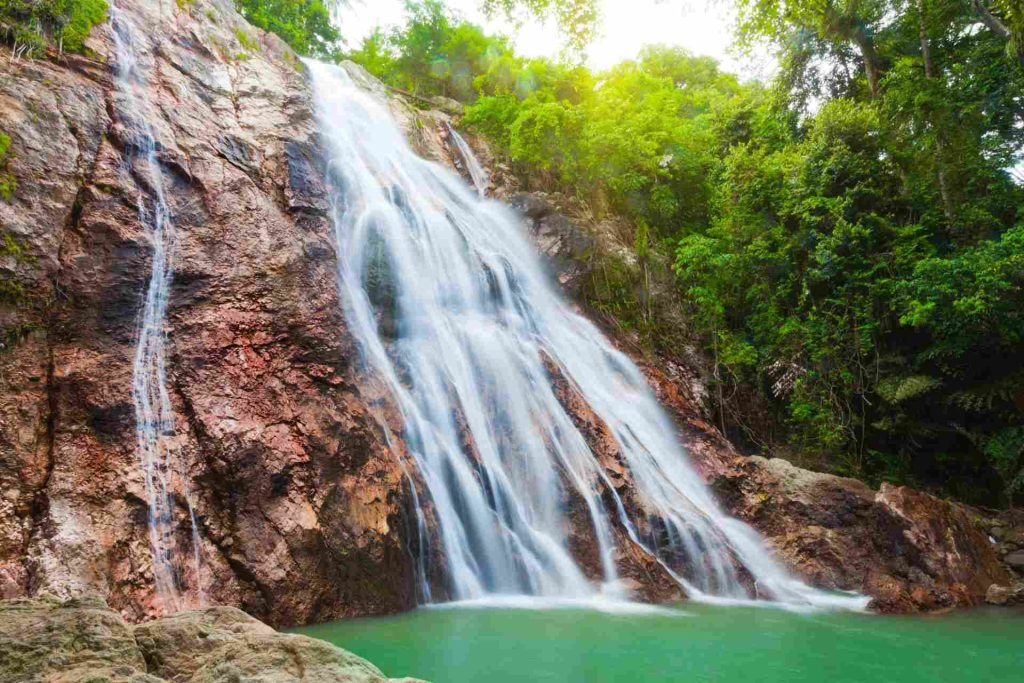 Na Muang waterfall surrounded by lush vegetation