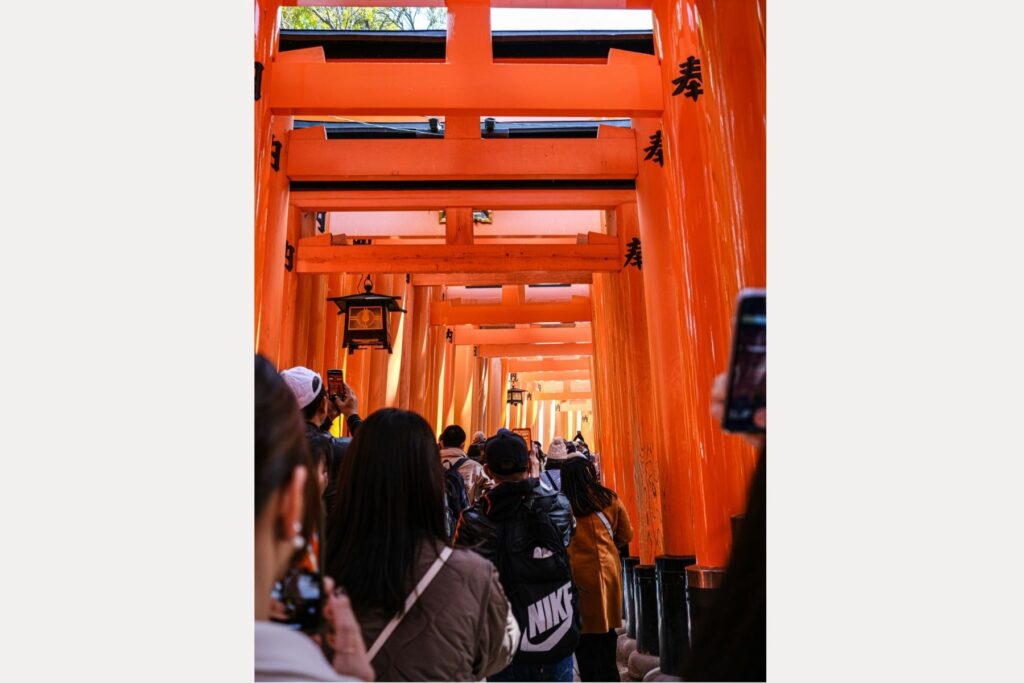 A line of tourists taking phones at a shrine in Japan