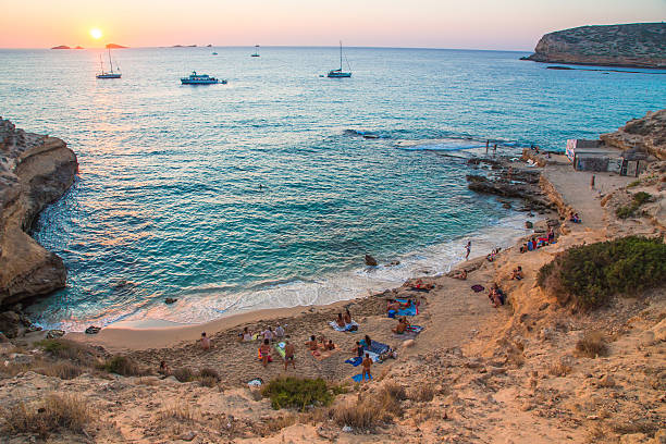 An arial shot of a group of people seeinf the sunset at Cala Comte, a popular beach in Ibiza