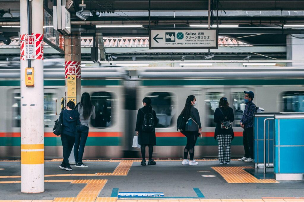 People at train station in Japan waiting to get on train.