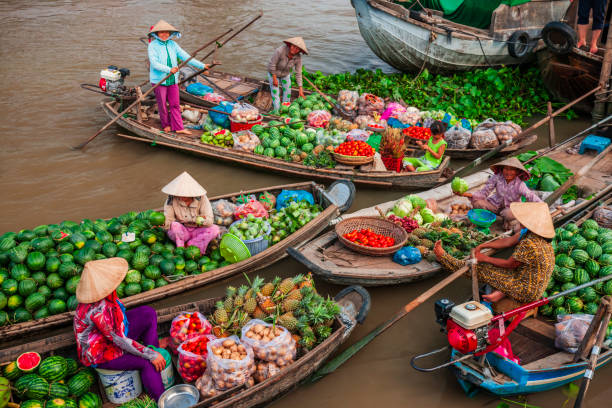 Vietnamese women selling and buying fruits on floating market, Mekong River Delta, Vietnam