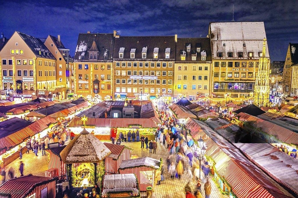 The iconic Christkindlesmarkt in Nuremberg, Germany, showcases its signature striped stalls and stunning backdrop of the historic Old Town. Source: Shutterstock