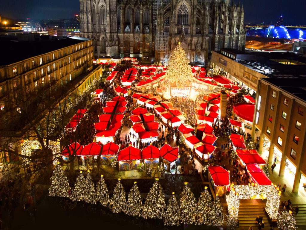 The Cologne Cathedral Christmas Market in Germany is a festive masterpiece, with its striking red stalls, dazzling Christmas tree, and the iconic Cologne Cathedral. Source: Cologne tourism