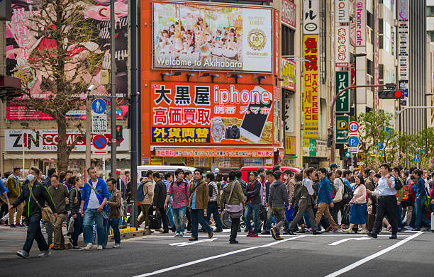 Pedestrians walking below the colorful signages of Japan’s Akihabara Street that’s popular for its Anime stores and Manga cafes.