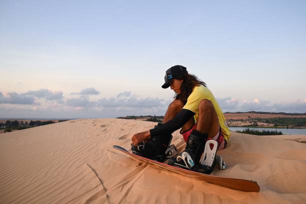 A tourist preparing to sandboard in the Mui Ne dunes; Source: Getty Images