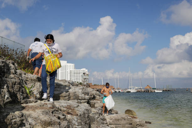 A cleaning brigade of three collecting trash on the coast of Playa Tortugas.