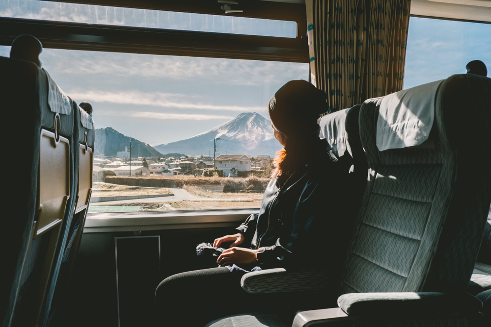 Traveler in a Shinkansen train watching the snowy mountains in Japan