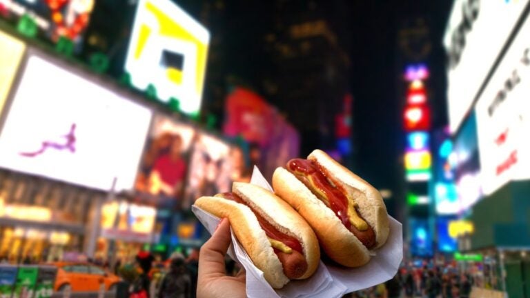 Enjoying a classic New York hotdog with a view of billboards