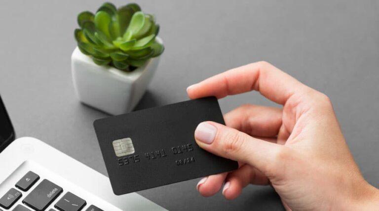 a hand holding a black credit card