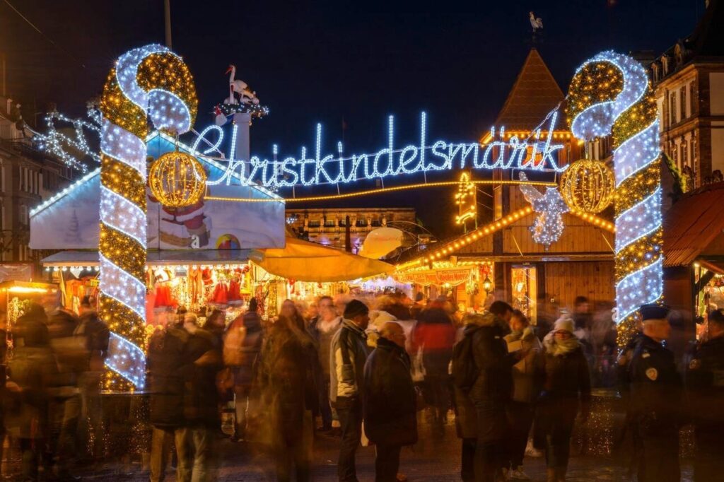 The enchanting Christkindelsmärik in Strasbourg, France, welcomes visitors with its glowing candy cane arch and vibrant festive lights. Source: Shutterstock