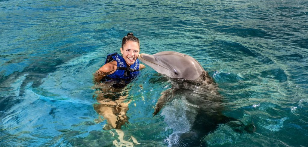 A visitor swimming with dolphins at Xcaret Park. Source: Xcaret