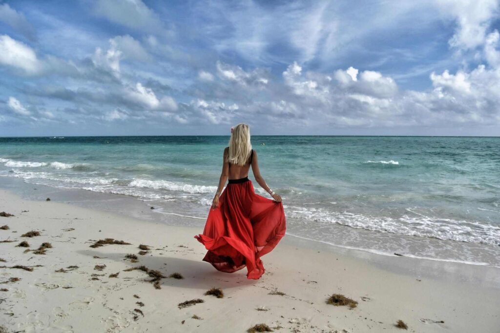 A woman in a red dress on a beach in the Bahamas