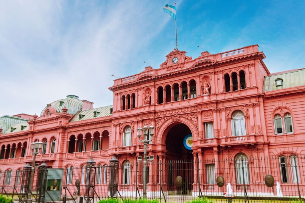 Frontal shot with a blue sky backdrop of the presedential palace, or Casa Rosada, Buenos Aires, Argentina.