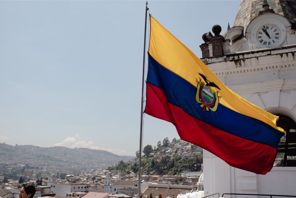 Close shot of the Ecuadoran flag amid a colonial city backdrop.