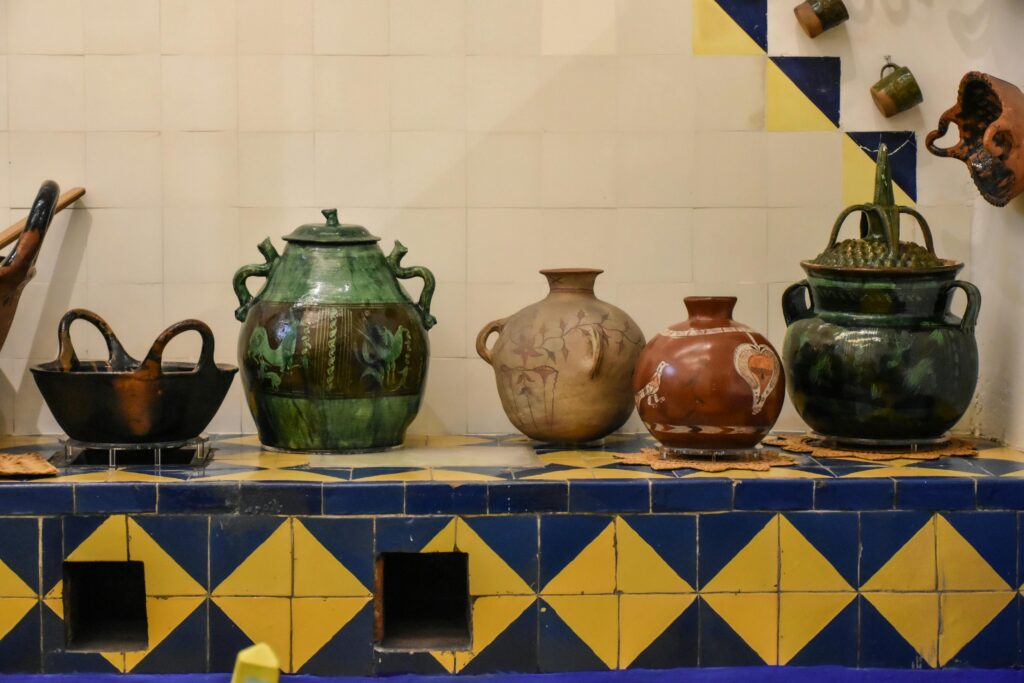 A display of colorful clay pots at the Frida Kahlo Museum in Mexico City, featuring vibrant colors that reflect the artist's personality. 