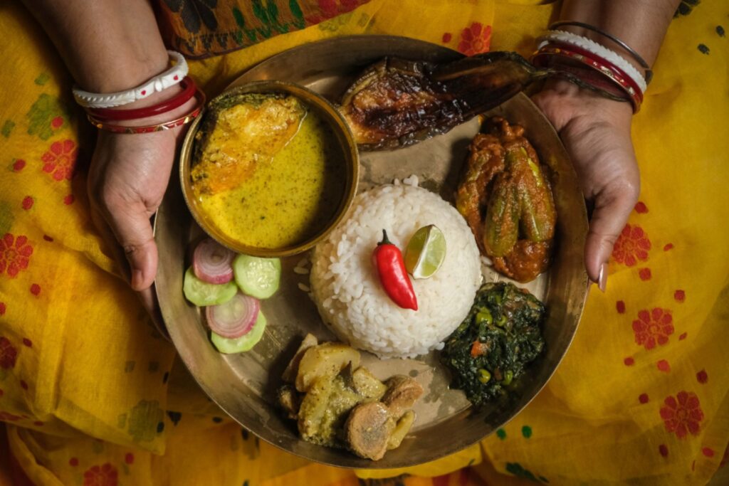 A woman holding a bowl of Indian cuisine