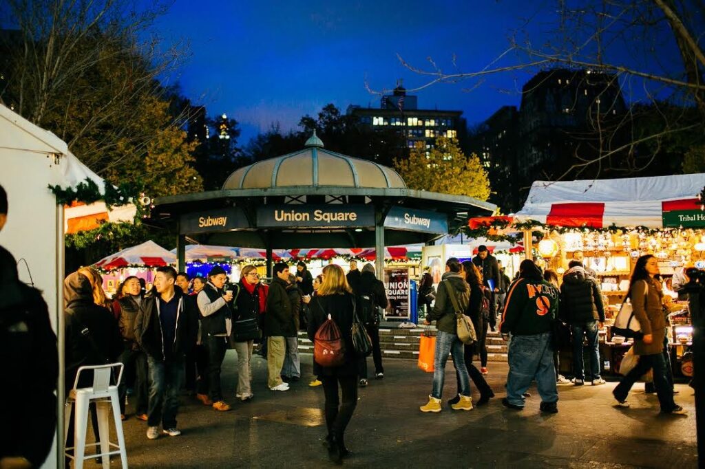 Union Square Holiday Market buzzes with shoppers enjoying festive stalls in NYC.