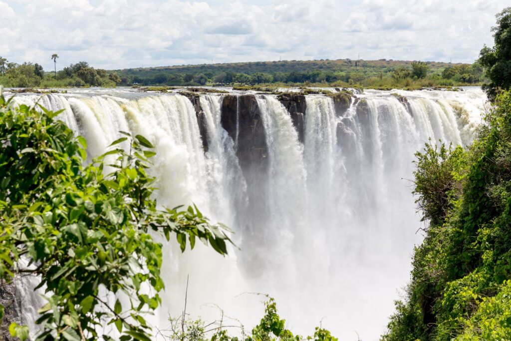 Wide shot of Victoria Falls and surrounding lush greenery.