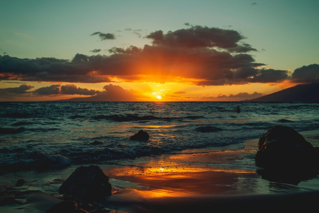 Watching the sunrise on a beach in the rustic area of Kula, on the Island of Maui; Source: Pexels