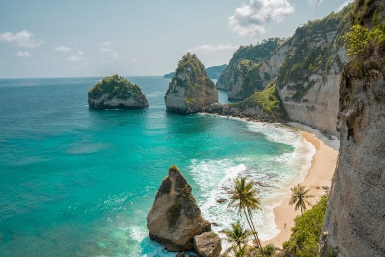 Dramatic cliffs and stunning rock formations line turquoise blue waters in Bali, Indonesia