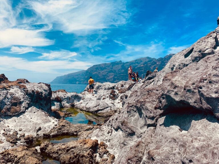 Young people exploring the rocky crags and tide pools of the Canary Islands, Spain.
