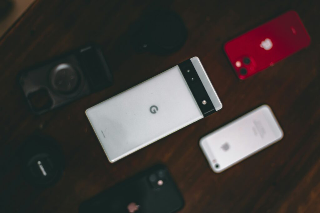 A white Google Pixel phone lying face down surrounded by other phones.