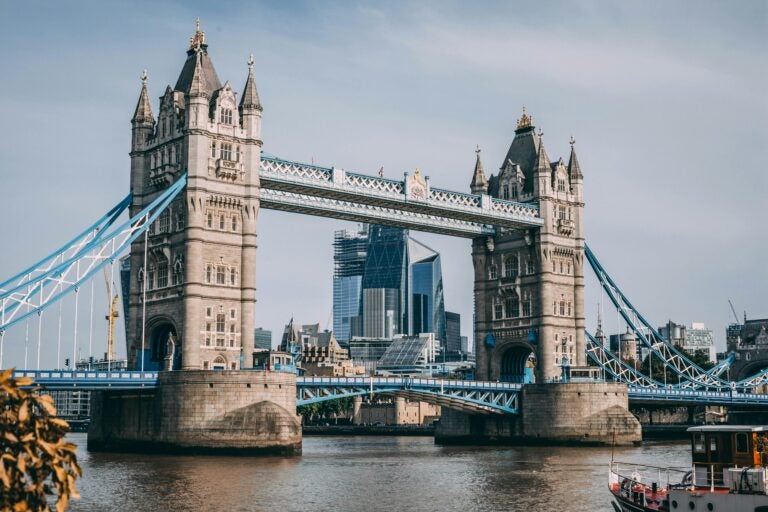Tower Bridge in London, England, with tall modern buildings in the background.