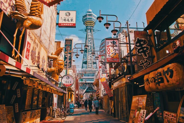 A retro-style street in Osaka, Japan with hues of orange, teal and red and fancy signs everywhere