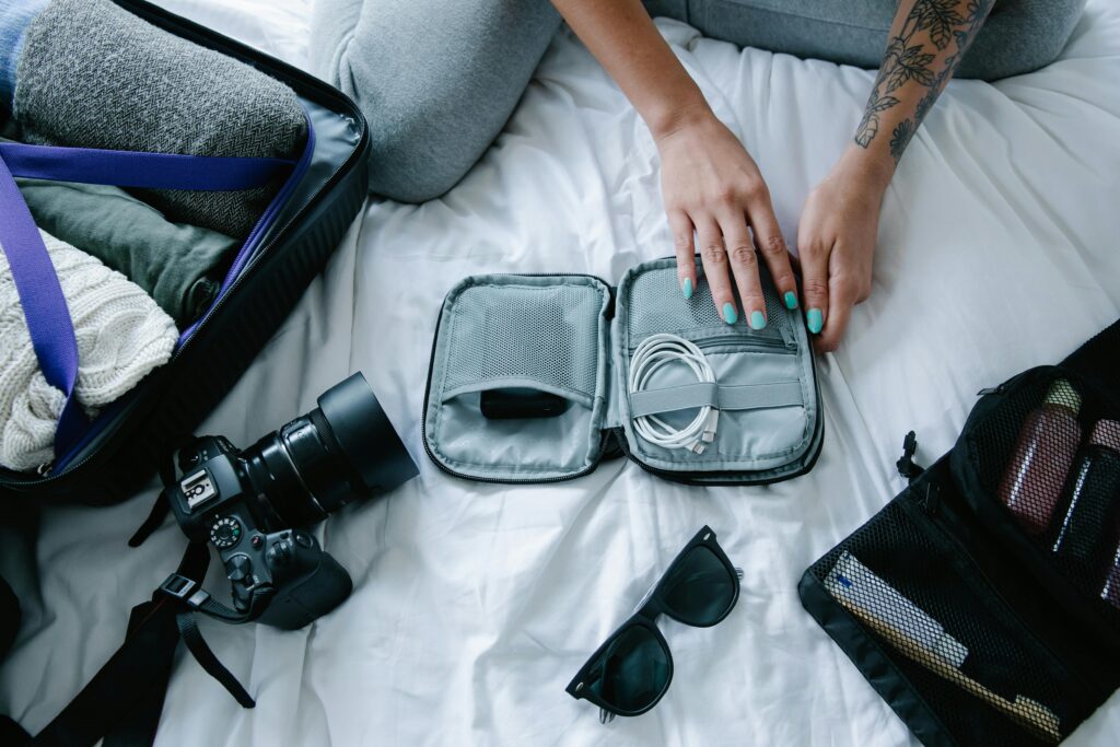 A traveler packing their gadgets and toiletries; Source: Pexels