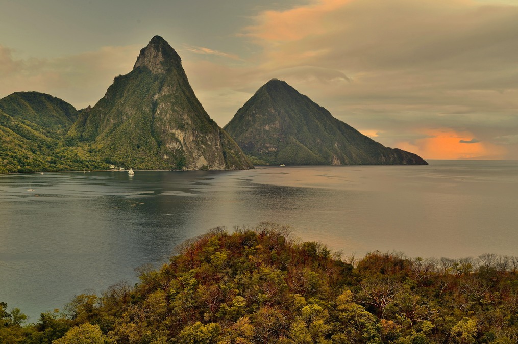 Mountainous landscapes stand tall against an orange sunset 