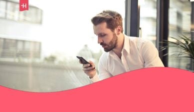 Businessman traveling for work, browsing his smartphone by the window.
