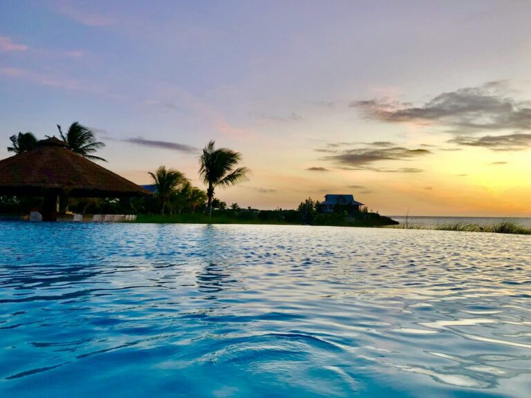 An infinity pool overlooking an orange sunset in The Bahamas