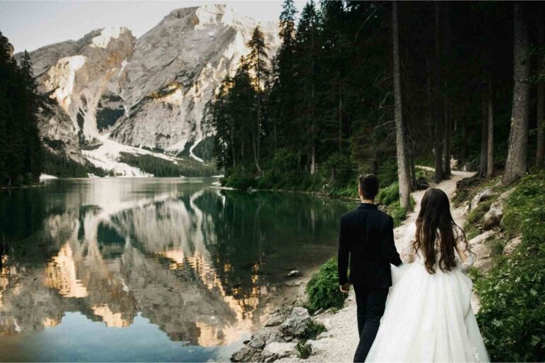 A newlywed couple walking in the Italian mountains