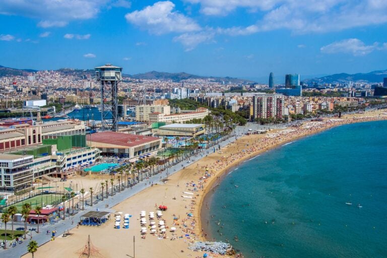 Aerial day shot of the promenade at Barceloneta Beach.