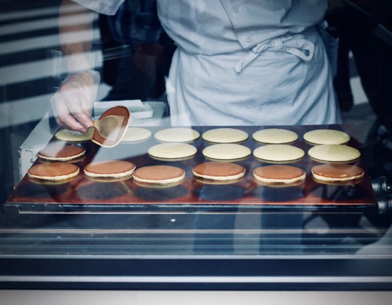 A chef making dorayaki through a shop window.