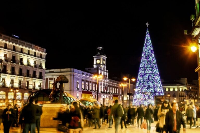Evening shot of a busy Sol Square, Madrid with large Christmas tree in the middle of the sqaure.