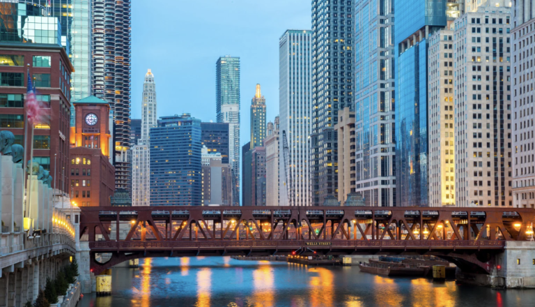 Lakefront evening shot of the Chicago city skyline and a bridge.