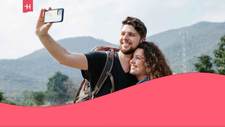 A young couple on vacation is taking a selfie to capture memories while exploring the outdoors.