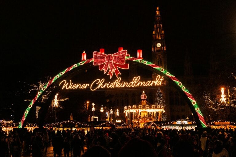 The illuminated entry archway to the Rathausplatz Christmas Market in Vienna.