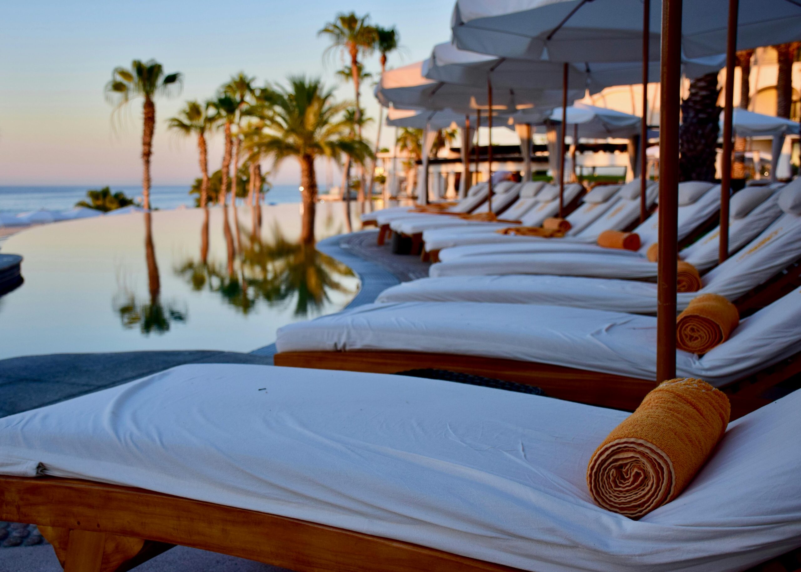 White sun loungers around a swimming pool in Mexico.