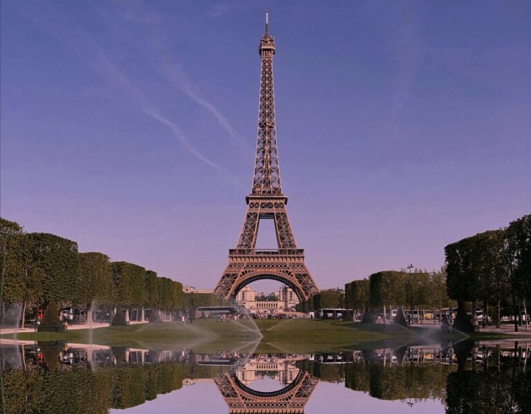 The Eiffel tower standing tall against a purple sky 