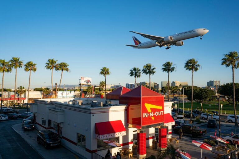 A plane flying overhead an In-N-Out joint in Los Angeles 