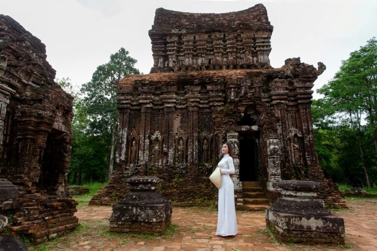 A person in a traditional white dress at My Son Sanctuary.