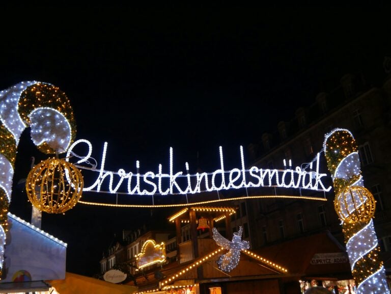 Illuminated candy cane-style archway leading into the Christmas Markets in Strasbourg.