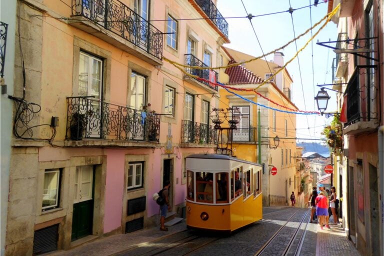 The streets of Lisbon with a cable car and pedestrians.